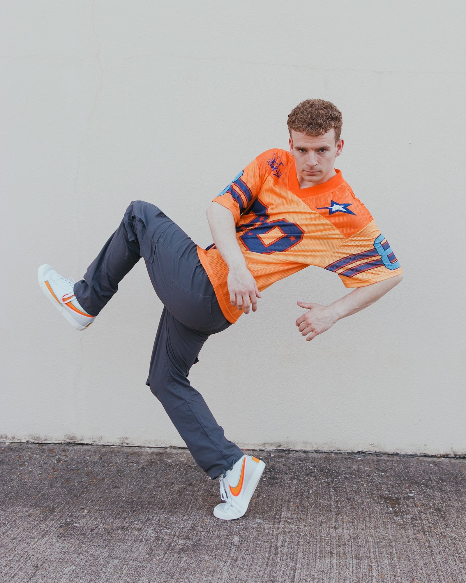 Andrew Stanifer mid-movement against a plaster wall